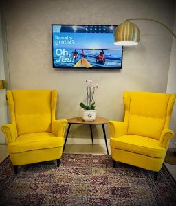 利多迪耶索罗Hotel Cristina的两个黄色的椅子和一张桌子