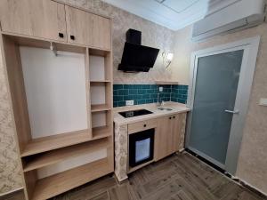伊斯坦布尔Lords Mansion的一间带水槽的小厨房和一台电视