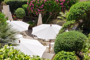卡尔维拉卡拉维尔酒店的一组白色的遮阳伞和鲜花椅子