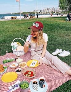 伊斯坦布尔Yıldız的坐在野餐毯上吃着食物的女人