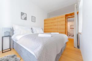 多瑙河畔克雷姆斯Cozy-City Appartement的卧室配有一张白色大床和木制床头板