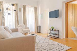 多瑙河畔克雷姆斯Cozy-City Appartement的白色的客厅配有白色的沙发和椅子