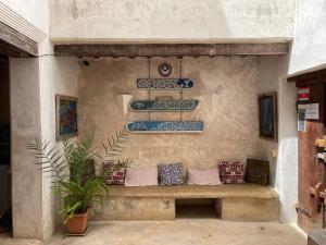 拉穆Authentic Swahili style villa Milele House的墙上的长凳,上面有蓝色和白色的板子