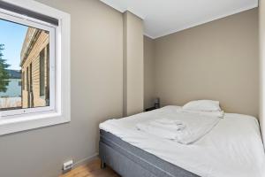 克里斯蒂安桑Ny sentral og moderne leilighet的白色的卧室设有床和窗户