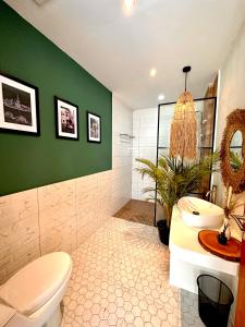 科贾扬Demoska Villa Jogja With Privatepool的浴室设有白色卫生间和绿色墙壁。