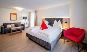 萨尔茨堡罗森维拉酒店的一间卧室配有一张床和一张红色椅子