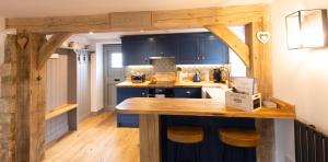 BledingtonCotswold cottage with hot tub的厨房配有蓝色橱柜和木制台面