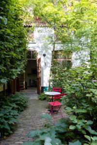 安特卫普Carriage House in quiet ecological garden的花园内的一张桌子和两张红色椅子