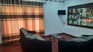 瓦都瓦villa senudri wadduwa的客厅配有两把椅子和一张桌子
