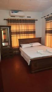 瓦都瓦villa senudri wadduwa的一间卧室配有床、镜子和窗帘