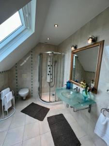 Manneville-la-Raoultailleurs sous les etoiles的一间带玻璃水槽和淋浴的浴室