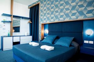 蒙泰迪普罗奇达Al Chiar di Luna的一间卧室配有蓝色的床和2条毛巾