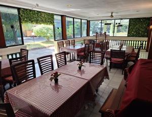 岩望Makati Pasuruan Hotel的餐厅设有桌椅和窗户。