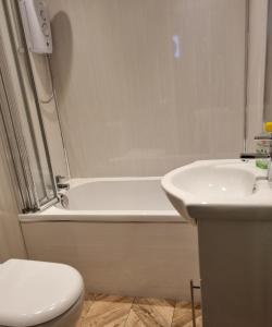 拉格斯Captivating 2-Bed ground floor Apartment in Largs的带浴缸、卫生间和盥洗盆的浴室