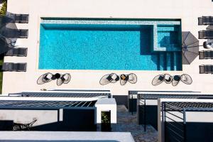 卡斯Carruba Boutique Hotel的建筑物一侧带太阳镜的游泳池