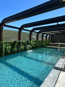 马塞拉韦尔Spa酒店的蓝色的海水和绿色的灌木游泳池