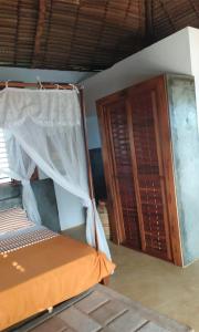 贝岛Hotel Océan Beach Sakatia的一间卧室配有一张床和一个木制橱柜