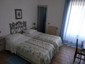 伊斯基亚Hotel Villa al Mare的一间卧室设有两张床和窗户。