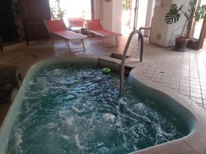 伊斯基亚Hotel Villa al Mare的热水浴池位于客房中间,配有水龙头