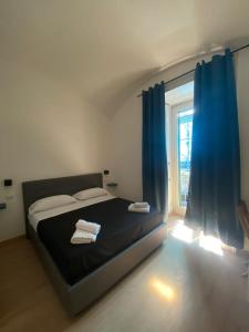 那不勒斯Maison Dante的一间卧室配有一张带蓝色窗帘的床和一扇窗户