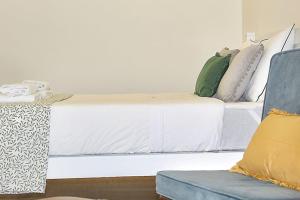 波尔图Oporto Sweet Downtown 2的卧室配有白色的床和蓝色的沙发