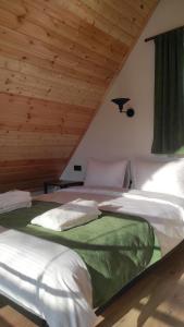 卡兹贝吉Cottage Milo Kazbegi的配有木天花板的客房内的两张床