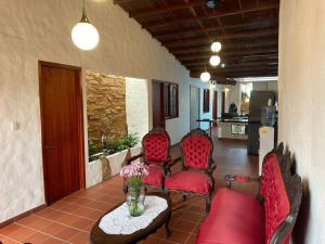 萨帕托卡Casa Victoria的客厅配有红色椅子和鲜花桌