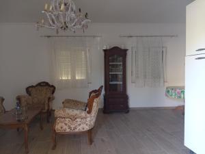 比奥格勒·纳·莫鲁Guesthouse Adriatic的客厅配有椅子、桌子和吊灯。