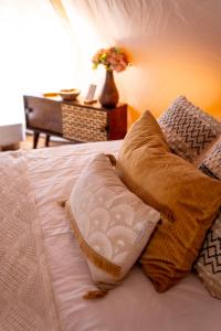 博维茨Glamping Gozdna Jasa的一张带两个枕头和花瓶的床