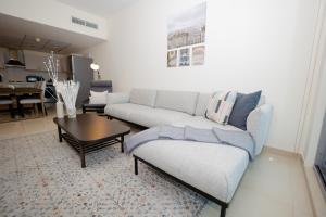 迪拜Newly furnished, spacious and modern 1BR in DIFC的客厅配有沙发和桌子