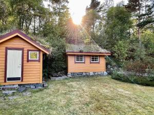 MosterhamnHoliday home MOSTERHAMN V的一座小小屋,位于一个阳光明媚的院子内