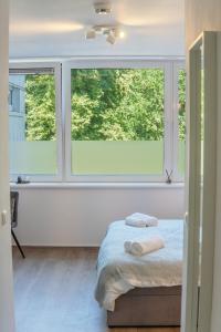 巴特塞格贝格Studio Apartment am Kurpark的一间卧室设有2扇窗户,床上配有毛巾
