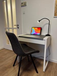 加格瑙City-Designapartment的一张桌子,上面有一台笔记本电脑和椅子