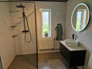 AlundaLantlig villa utanför Uppsala的带淋浴、盥洗盆和镜子的浴室