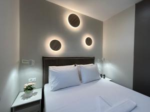 依拉佩特拉Armonía Small Luxury Apartments的卧室配有一张带两盏圆形灯的墙壁床。