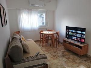 布宜诺斯艾利斯Hermoso departamento en el corazón de Palermo Soho的带沙发、电视和桌子的客厅