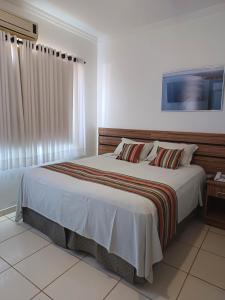 三玛丽亚镇Hotel Estrela Mares的一间卧室设有一张大床和一个窗户。