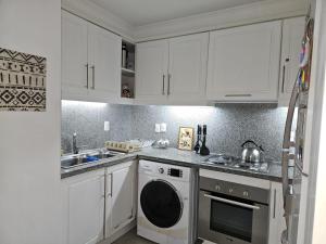 埃斯特角城Green Park penthouse 2 dormitorios的厨房配有白色橱柜和洗碗机。