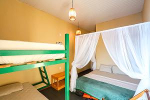 马瑙斯Abaré floating Lodge的一间卧室配有两张双层床和白色窗帘