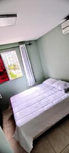 戈亚尼亚Apartamento Aconchegante的窗户和床罩的房间里的一个床位