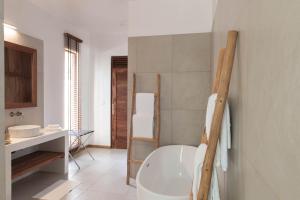 帕杰桑希巴白沙豪华别墅Spa度假村 - 罗莱夏朵精品酒店的浴室配有白色浴缸和水槽