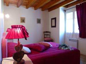 莱卡巴讷Gite d'Appy的一间卧室配有一张带灯的紫色床