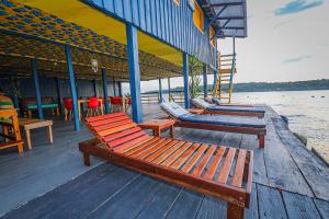 马瑙斯Abaré floating Lodge的坐在水边码头上的一排长椅