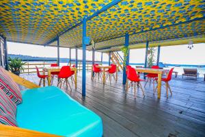 马瑙斯Abaré floating Lodge的一个带桌椅和长凳的有盖甲板