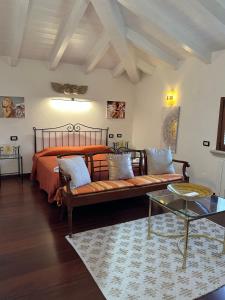 圣温琴佐Bougainville的一间卧室配有一张床、一张沙发和一张桌子