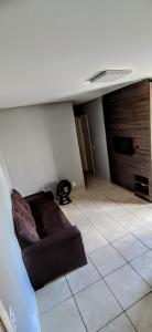 戈亚尼亚Apartamento Aconchegante的客厅铺有瓷砖地板,配有沙发。