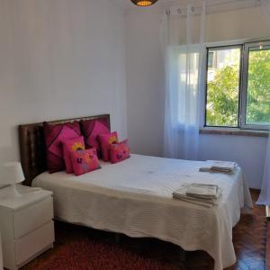 里斯本Sun House Belem -Free Paking and View Tower的卧室配有一张带粉红色枕头的大床