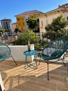 卡利亚里Sunset 221 Cagliari的阳台配有2把椅子和1张桌子