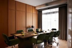 塞萨洛尼基Noa Hotel的一间会议室,配有桌子和绿色椅子