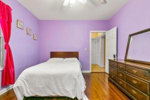 布里奇波特The Pink Room near Yale Hospital/Bridegport的一间卧室设有紫色的墙壁、一张床和一个梳妆台